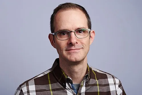 （身着程序员标志套装的 John）