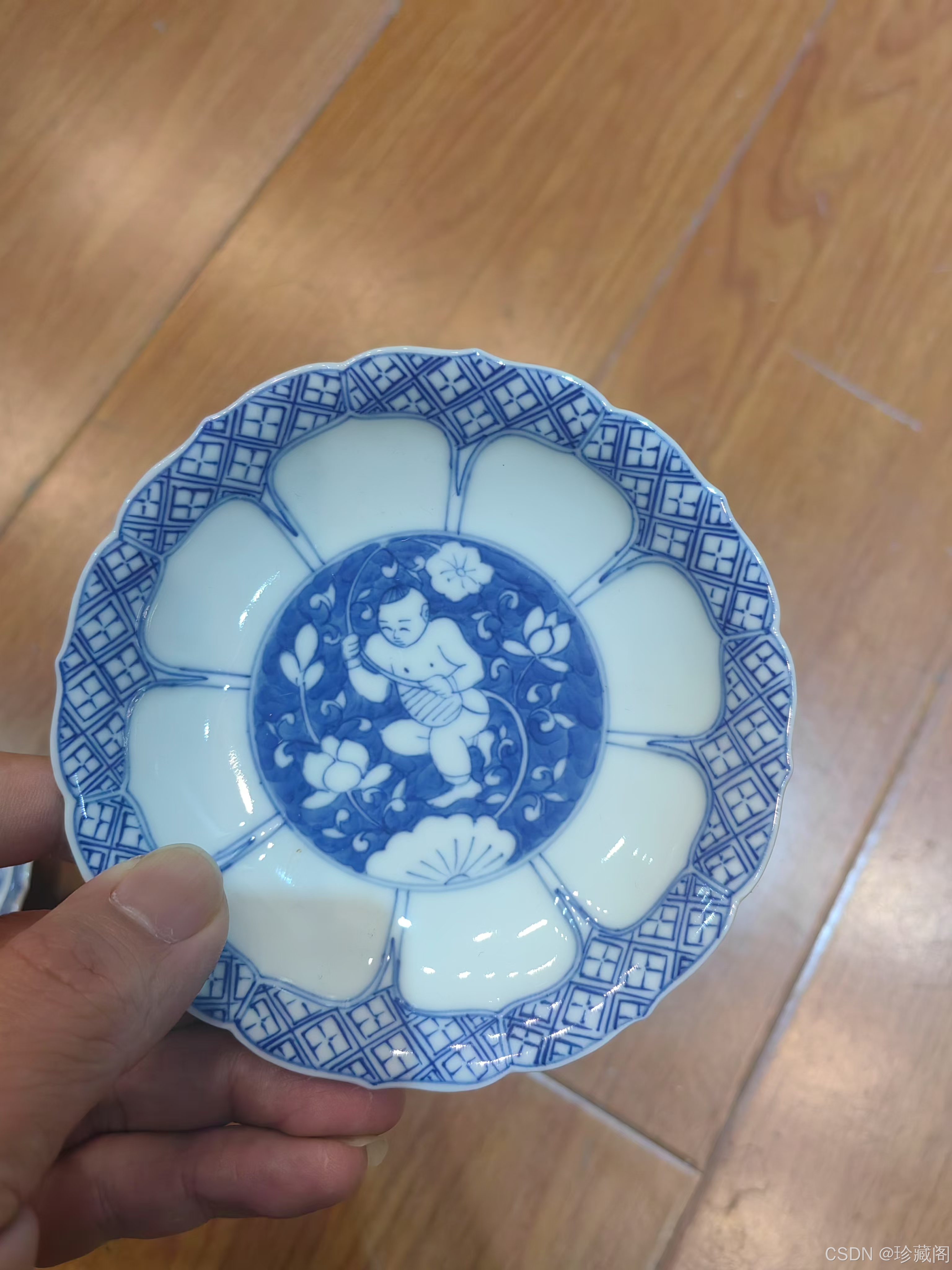 康熙青花执莲童子纹葵口杯碟一套，因其工艺精湛、纹饰吉祥、器型独特