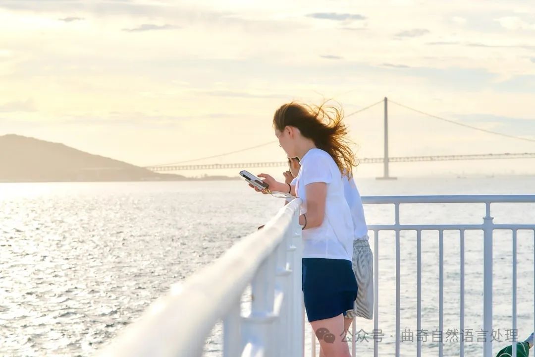 A woman standing on a bridge looking at her cell phone