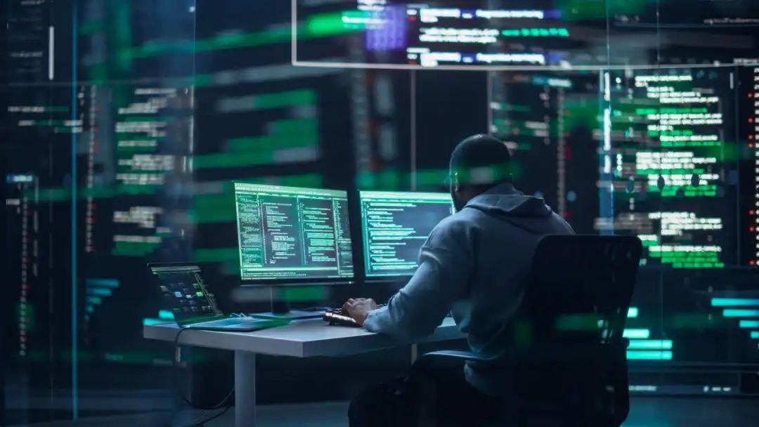 programmer writes software code on background of screens