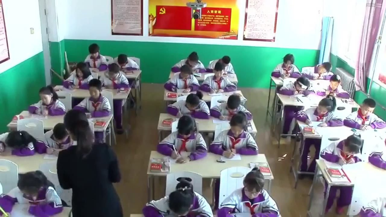 教师在课堂中巡视，学生认真书写的场景